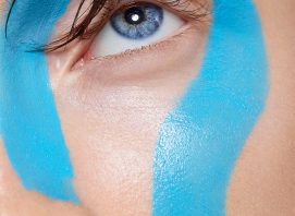 Closeup of woman's face with blu paint makeup